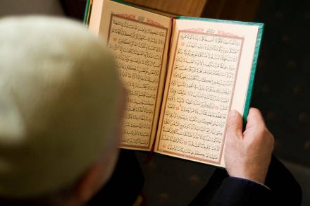 Muslim man reading Koran in mosque, available light from window. Istanbul/Turkey.